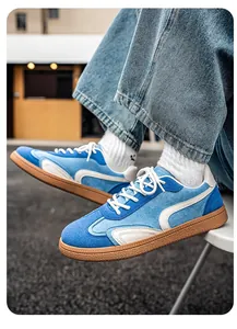 Gros plan de baskets GAT en daim bleu portées avec un jean sur une semelle en gomme