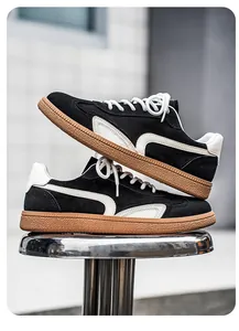 Vue latérale de baskets GAT en daim noir avec détails blancs et semelles en gomme