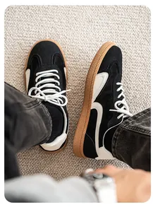 Vue de dessus de baskets en daim noir pour hommes avec semelle gomme sur tapis