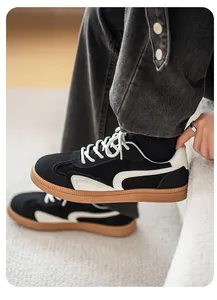 Vue latérale de baskets d'entraînement allemandes pour hommes noir et blanc, semelle gomme