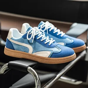 Baskets pour hommes bleues et crème de style GAT avec semelle épaisse sur une chaise moderne.
