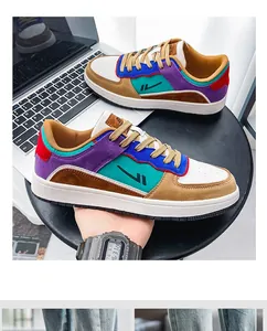 Close-up of vibrant multi-color men's skate shoes displayed on a table with a laptop