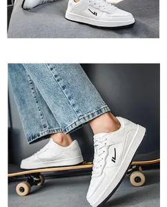 Detailed shot of men's white leather board shoes on a skateboard with denim jeans