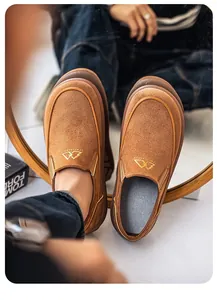 Detalle de mocasines retro de ante marrón para hombre con suelas gruesas de goma de calidad