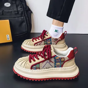 Stylish men's shell-toe platform sneakers with ethnic woven patterns and red laces.