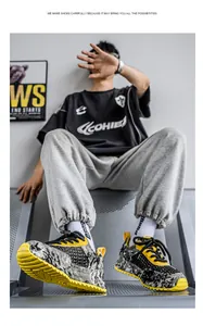Dettaglio ravvicinato delle sneakers chunky in mesh traspirante con motivo graffiti giallo e nero
