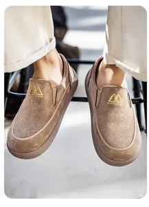 Primer plano de mocasines de ante marrón para hombre con detalle de logo