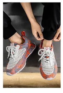 Dettaglio di sneaker da uomo in mesh traspirante con motivi blu e arancioni vivaci