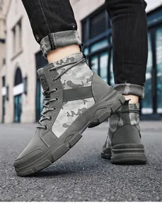 Nahaufnahme von grauen Camouflage-Herrenstiefeln im taktischen Design auf Stadtpflaster