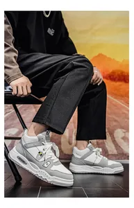 Vista dettagliata delle sneakers alte da uomo grigie e bianche in un ambiente urbano