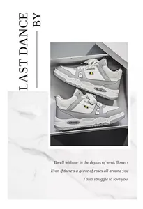Vista dettagliata di sneaker alte grigie e bianche in una scatola su fondo marmo