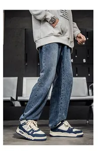 Sneaker alte da uomo in blu navy e beige abbinate a jeans in un contesto urbano