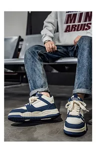 Dettaglio ravvicinato di sneaker alte alla moda blu navy e crema da uomo in posa