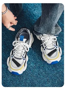 Top-down detail view of men's retro chunky sneakers dad shoes on a blue carpet
