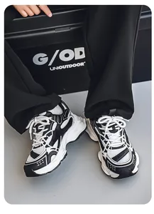 Close-up of black and white chunky dad sneakers with mesh and synthetic overlays