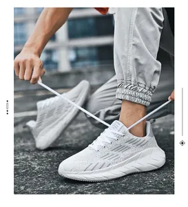 Uomo che allaccia scarpe sportive in mesh bianco traspirante in ambiente esterno