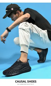Uomo accovacciato con scarpe da corsa sportive in rete traspirante nera su sfondo blu