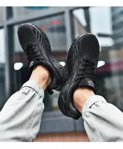 Foto lifestyle di scarpe da corsa in mesh nero traspirante con suola strutturata.