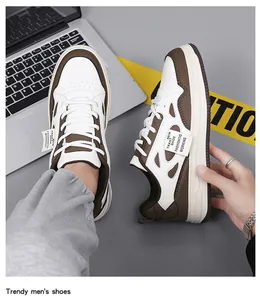 Primer plano de zapatillas de hombre blancas y marrones en un escritorio con laptop