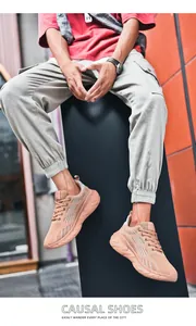 Vista dettagliata delle scarpe da corsa da uomo in mesh pesca in un contesto urbano