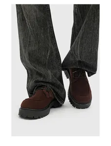 Vista dettagliata di scarpe derby in camoscio marrone con suole platform stile vintage