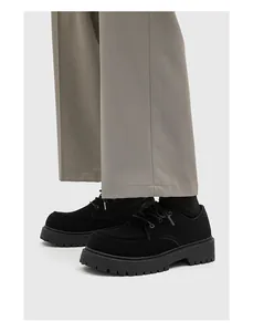 Primo piano di scarpe Derby nere con suola a piattaforma in stile workwear robusto