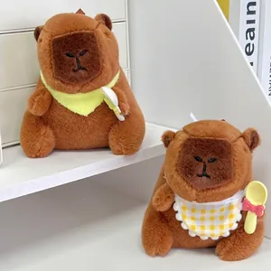 Detail van schattige capibara pluche sleutelhangers met slabbetje en lepel op een plank.