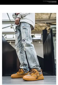 Gedetailleerd zijaanzicht van trendy mosterdgele herensneakers met gescheurde spijkerbroek