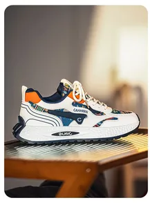 Seitenprofil weißer Chunky-Herren-Sneaker mit ethnischem Muster und orangen Akzenten