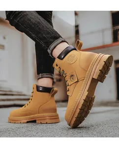 Dettaglio di stivali da lavoro giallo senape da uomo con suola robusta e logo laterale.