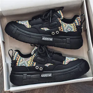 Zwarte chunky sneakers met kleurrijke etnische patrooninzetten in een witte schoenendoos