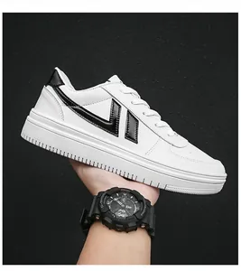 Vista dettagliata di sneakers bianche casual per studenti tenute in mano su sfondo nero