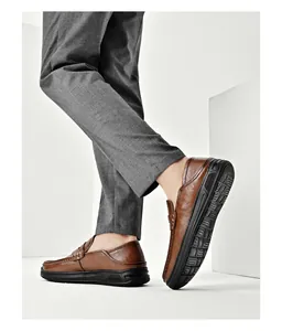 Close-up detail of men's brown soft leather loafers with durable black rubber soles