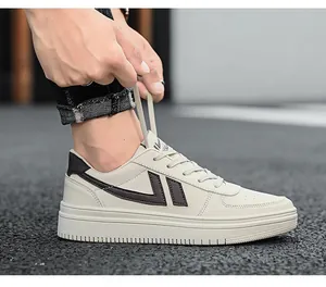 Vista dettagliata di sneakers casual crema con logo a V nero su fondo stradale in asfalto