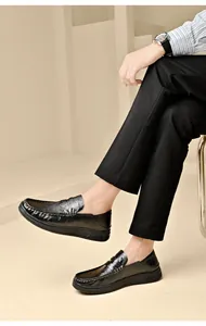 Detailed macro view of men's black soft leather loafers worn with casual trousers