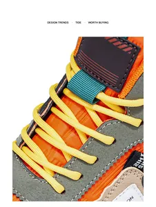 Primer plano de botas de montaña con cordones amarillos y detalles de malla naranja vibrante.