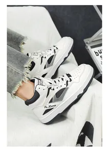 Dettaglio ravvicinato di sneakers alte bianche con accenti neri e marchio Pu Xiong