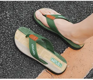 Detailansicht robuster Herren Flip-Flops mit grünen Stoffriemen auf Asphalt