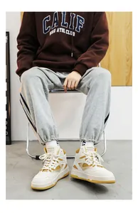 Vista ravvicinata di sneakers alte da uomo alla moda in bianco e giallo per inverno