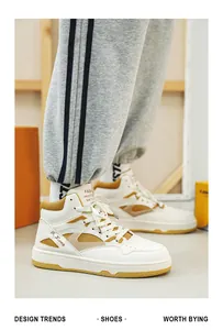 Vista laterale professionale di sneakers alte bianche con accenti gialli e pantaloni grigi