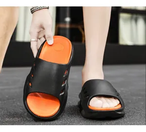Stylish men's sports slides with thick soles in black and orange, featuring non-slip texture.