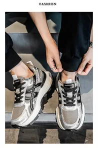 Κοντινό πλάνο από ασημί και μαύρα ανδρικά sneakers με χοντρή σόλα και μοντέρνο στυλ.