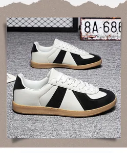 Detailed side view of classic black and white men's German Army Trainers with gum sole