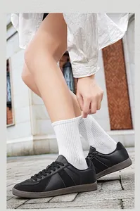 Close-up of black German Army Trainers featuring leather and suede paneling design