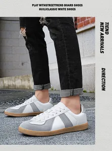 Close-up of white and grey German Army Trainers with gum soles on pavement