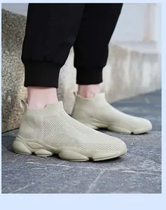 Gros plan de baskets beiges sans lacets en maille respirante pour hommes sur pavé