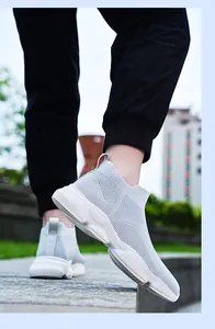 Vue extérieure dynamique de baskets chaussettes grises respirantes en fly-knit pour hommes.