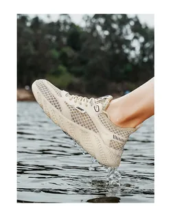 Detailed action shot of breathable beige mesh men's sneaker splashing in river water