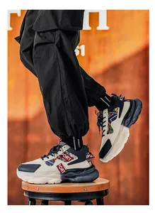Elegante cremefarbene und marineblaue Chunky-Sneaker mit roten Akzenten und Stoffmustern.