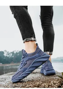 Breathable blue mesh running sneakers for men shown in a natural outdoor lake setting